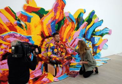 Artist Liu Bolin mid-way painting through his first live UK performance The Disappearing Act in London's Saatchi Gallery