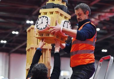 An exhibitor puts the finishing touches to a model of the Houses of Parliament's Elizabeth Tower (Big Ben) made from Lego to illustrate Embedded inside parliament, influence of academics grows