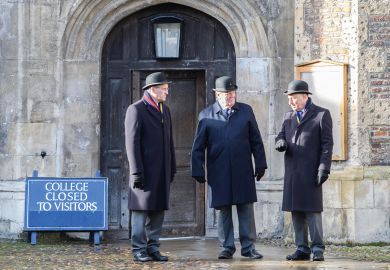 Trinity college at the University of Cambridge, England. Men standing at closed door with sign reading 'College to to visitors' to illustrate Elitism cannot be fixed without Oxbridge admissions reform