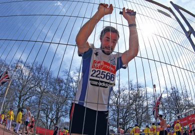 An exhausted competitor attempts to recover after crossing the finish line to illustrate Administrator burnout risks ‘destabilising’ universities