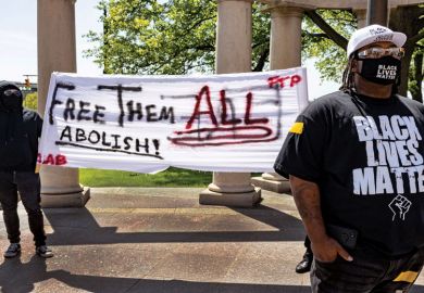 Black Lives Matter activist stands in front of other activists that advocate for abolishing the police during a rally against police brutality in front of the Columbus City Hall in Columbus, Ohio on May 1, 2021