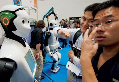 Two visitors check out humanoid robot REEM of Spanish engineering company PAL Robotics at the Automatica trade fair in Munich, southern Germany 