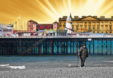 A metal detectorist searching on the shingle beach near Brighton Pier in East Sussex.