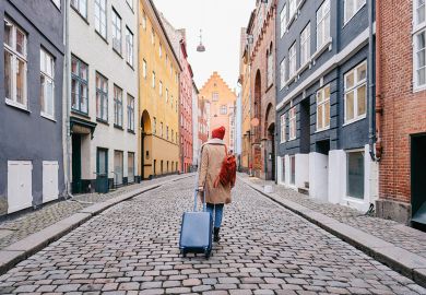 A woman walking down the street pulling a suitcase A woman walking down the street and pulling a suitcase to illustrate wanting to leave
