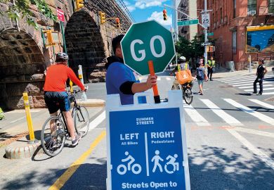 Traffic volunteer holding Go sign in Manhattan, New York City to illustrate Gates Foundation open access move ‘shifts needle in right direction’