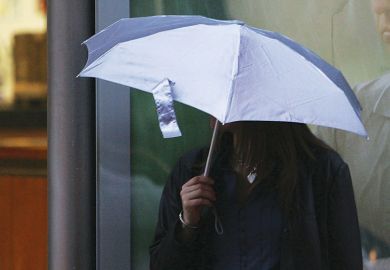 Woman holding umbrella over her head Woman holding umbrella over her head to illustrate Afghan Chevening scholars ‘let down’ by UK universities
