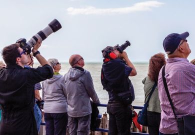 Group of photographers look to the sky waiting ready to take pictures.
