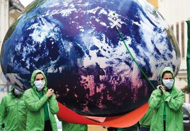 People carry a giant balloon of planet Earth. People carry giant balloon of planet Earth as a metaphor to the climate crisis is undeniably a global challenge