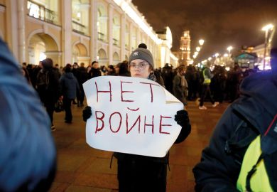 demonstrator holds a banner during an anti-war protest in Saint Petersburg, Russia to illustrate Russia punishes anti-war stance with expulsions