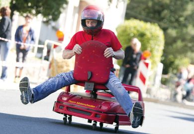 Man racing on an office chair Man racing on an office chair to illustrate Universities must go hybrid to stay relevant, says Coursera CEO
