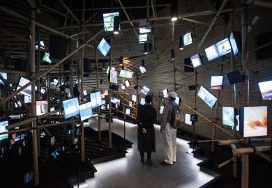 Exhibition hall with irregular arrangement of multimedia screens in Milan to illustrate Major universities play catch-up as Italian students move online