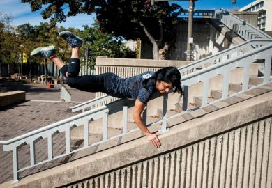 A lady vaults over a stair railing A lady vaults over a stair railing as a metaphor for a quarter of US states ‘likely to skip’ Biden free college plan