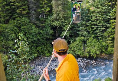  Man pulling hikers across the hand tram at Winner Creek to illustrate US research funding emerges as election battleground