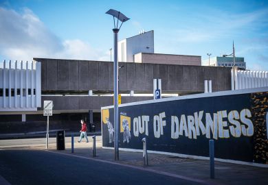  A hoarding surrounds a brownfield site waiting for redevelopment in the Horseley Fields area of Wolverhampton with graffiti reading 'Out of the darkness' to illustrate Post-92s ‘inspire and drive social mobility’