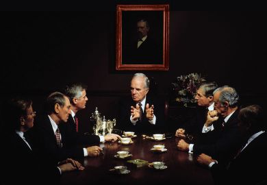 Group of men sitting at a table in a business meeting to illustrate How I learned that keeping men at the top was leaders’ real task