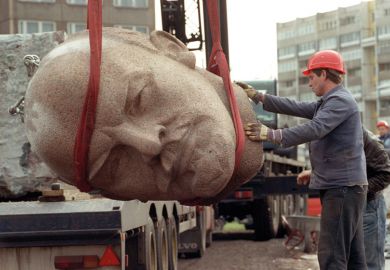 Worker removing the head of a statue representing late Soviet leader Vladimir Ilyich Lenin to represent Amid war, Russian 101 enrolments plummet at Western institutions