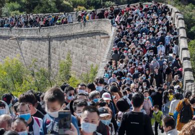 People crowd in a bottleneck as they move slowly on a section of the Great Wall at Badaling to illustrate  Overseas students struggle to get documents to return to China