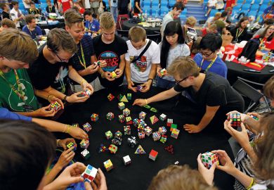Competitors solve Rubik's cubes to illustrate Restoring trust in university learning is child’s play