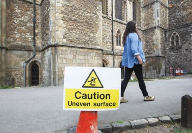 A caution uneven surface is seen while a woman walks past. A caution uneven surface is seen while a woman walks past as a metaphor fo, Experts urge caution on positive UK study visa data