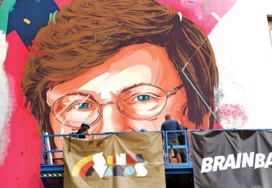 A painter makes finishing touches on a mural showing a portrait of Katalin Kariko as she is mentioned in the story