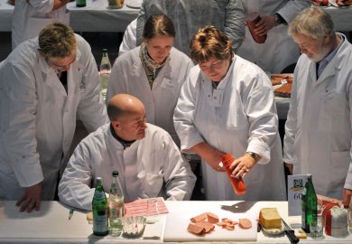 Food testers evaluate products during a quality check for ham and sausage as a metaphor for quality and control