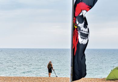 A man walks along Brighton Beach using a metal detector. A man walks along Brighton Beach using a metal detector to illustrate Programs are not detecting AI text. Is regulation needed to halt cheats?