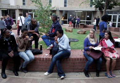 Students chat outside lecture halls at the University of the Free State in Bloemfontein, South Africa. Races are mixing more but often they socialize with their own kind. Students chat outside lecture halls at the University of the Free State in Bloemfontein, South Africa. Races are mixing more but often they socialize with their own kind.