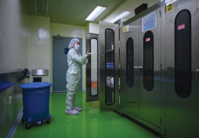 A lady putting on protective clothing required to enter a testing lab A lady putting on protective clothing required to enter a testing lab