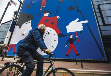 A man rides a bicycle past a wall painting