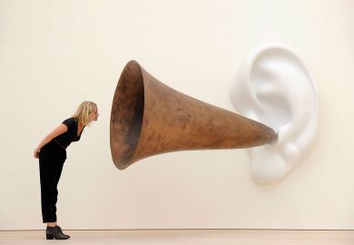 Woman leans in looking at an installation of an ear on a wall with a trumpet. Woman leans in looking at an installation installation by US artist John Baldessari entitled ‘Beethoven’s Trumpet (With Ear)’ as a metaphor for universities will ‘listen to students’