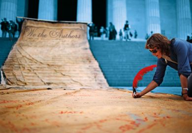 A woman  signs a giant banner to illustrate Editors have become so wayward that authors need a bill of rights