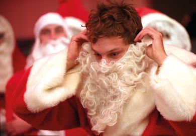 A participant puts on his Santa beard during a gathering of volunteer student Santas and angels in Berlin, Germany