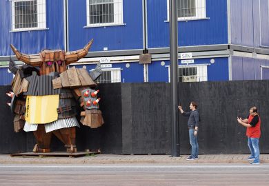 Tourist take photos of a wooden statue of Viking in helmet at the ecological construction site on Jatkasaari island in Helsinki, Finland to illustrate Will Finland’s spending on  R&D buy it the gift of growth?