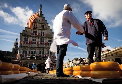 Shaking hands with a Cheesemaker at a market at the opening of the Dutch Cheese season in Gouda Shaking hands with a Cheesemaker at a market at the opening of the Dutch Cheese season in Goudato illustrate UK universities near Elsevier deal after publisher drops price