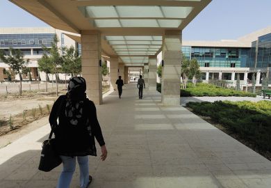 Student walks through campus during her fourth year on scholarship at the American University of Iraq to illustrate Afghan students ‘in doldrums’ at Iraqi university