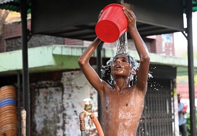 A child is taking a bath from a roadside water pipeline during a heatwave in Dhaka, Bangladesh