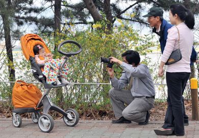 A South Korean man takes a photo of his baby sitting on a pushchair during their family picnic  A South Korean man takes a photo of his baby sitting on a pushchair during their family picnic to illustrate Korean excellence plan shortlist drafted