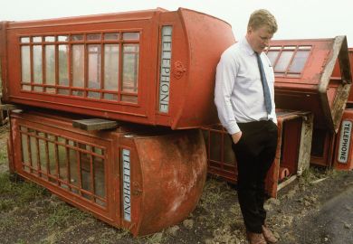 Person with  with old phone boxes for sale