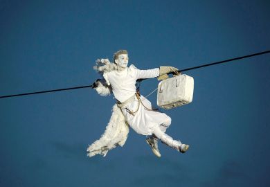 A performer is suspended from high-wires during the outdoor aerial performance of  a show