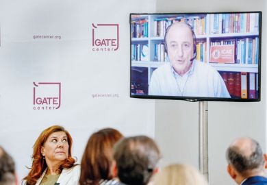 Person speaks via videoconference during an in person meeting to illustrate Conferences don’t see a hybrid future