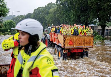 People are being evacuated in a tractor trailer in a flooded street as a metaphor for  Europe mulls ‘war games’ to brace for future crises