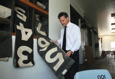 Man holding an old scoreboard Man holding an old scoreboard as a metaphor for Staff counts are a numbers game