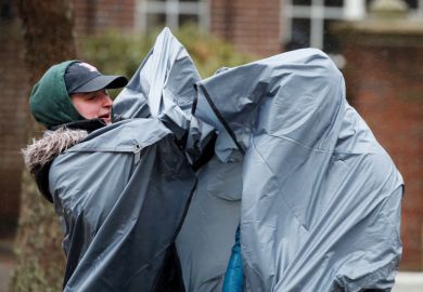 Spectators struggle with the elements while waiting  to illustrate edX sale to 2U leaves both  sides struggling