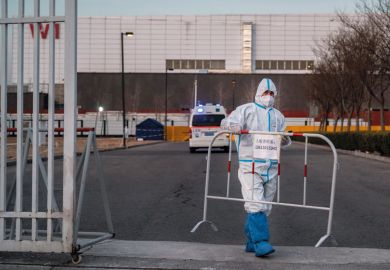 A worker places a barrier in Beijing, China to illustrate ‘Collective crawling’ and cardboard dogs ‘are creative protests’