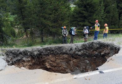 Hikers looking at a sinkhole that measures 25x20 feet and approximately 50-60 feet deep in Colorado Hikers looking at a sinkhole that measures 25x20 feet and approximately 50-60 feet deep in Colorado to illustrate Review finds billion-dollar hole in Johns Hopkins medicine budget