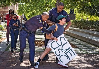 Holding a sign that said Sue USC a USC student is arrested by campus police in USC Village after calling for USC to sued and held accountable for their actions surrounding the pro-Palestinian protest on campus on Monday, May 6, 2024 in Los Angeles, CA Holding a sign that said Sue USC a USC student is arrested by campus police in USC Village after calling for USC to sued and held accountable for their actions surrounding the pro-Palestinian protest on campus on Monday, May 6, 2024 in Los Angeles, CA
