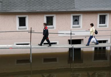 People walking on a tempory bridge in Germany People walking on a tempory bridge in Germany as a metaphor for precariously employed German academics