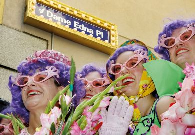 Four Dame Edna Everage look-alikes pose under the street sign as city laneway in Melbourne' to illustrate Enrolment caps risk monoculture in Australian HE, economist warns