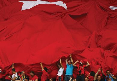 Fans of Turkey roll out the Turkish flag in support of their team