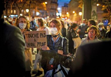 A member of the crowd watching the National Tribute to the murdered school teacher Samuel Paty holds a placard reading 'Do not touch my Professor' at Place de la Sorbonne on October 21, 2020 in Paris, France  A member of the crowd watching the National Tribute to the murdered school teacher Samuel Paty holds a placard reading 'Do not touch my Professor' at Place de la Sorbonne on October 21, 2020 in Paris, France.